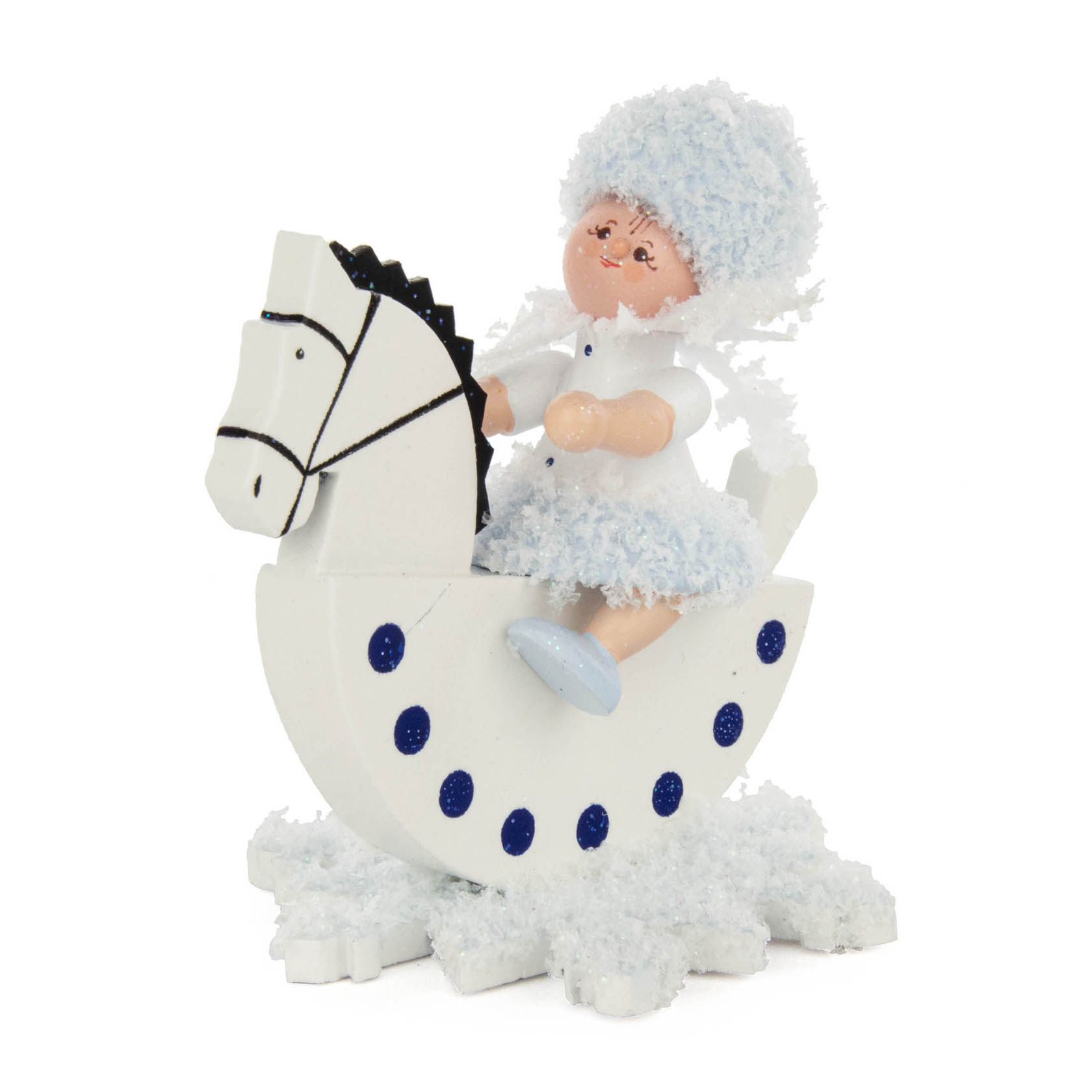 Kleine Puppe im Winterkostüm sitzt auf einem weißen Schaukelpferd, dekoriert mit blauen Punkten. im Dregeno Online Shop günstig kaufen