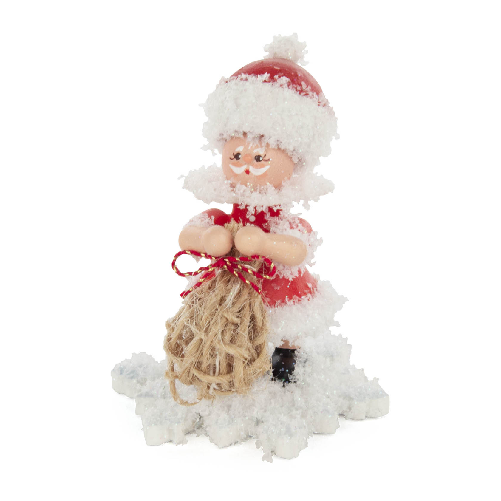 Eine kleine Schneefigur in Form eines Weihnachtsmanns mit weißem Bart, rotem Anzug und einem Jutesack in den Händen, umgeben von Kunstschnee. im Dregeno Online Shop günstig kaufen