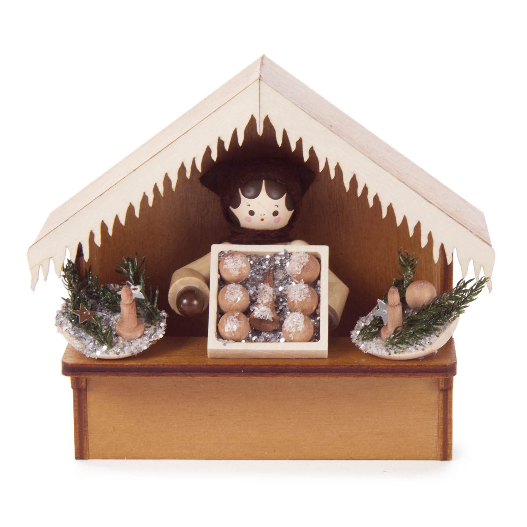 Holzfigur als Verkäufer unter einem Holzdach, bietet eine Kiste mit Christbaumschmuckkugeln an, dekoriert mit kleinen Tannenbaumästen. im Dregeno Online Shop günstig kaufen