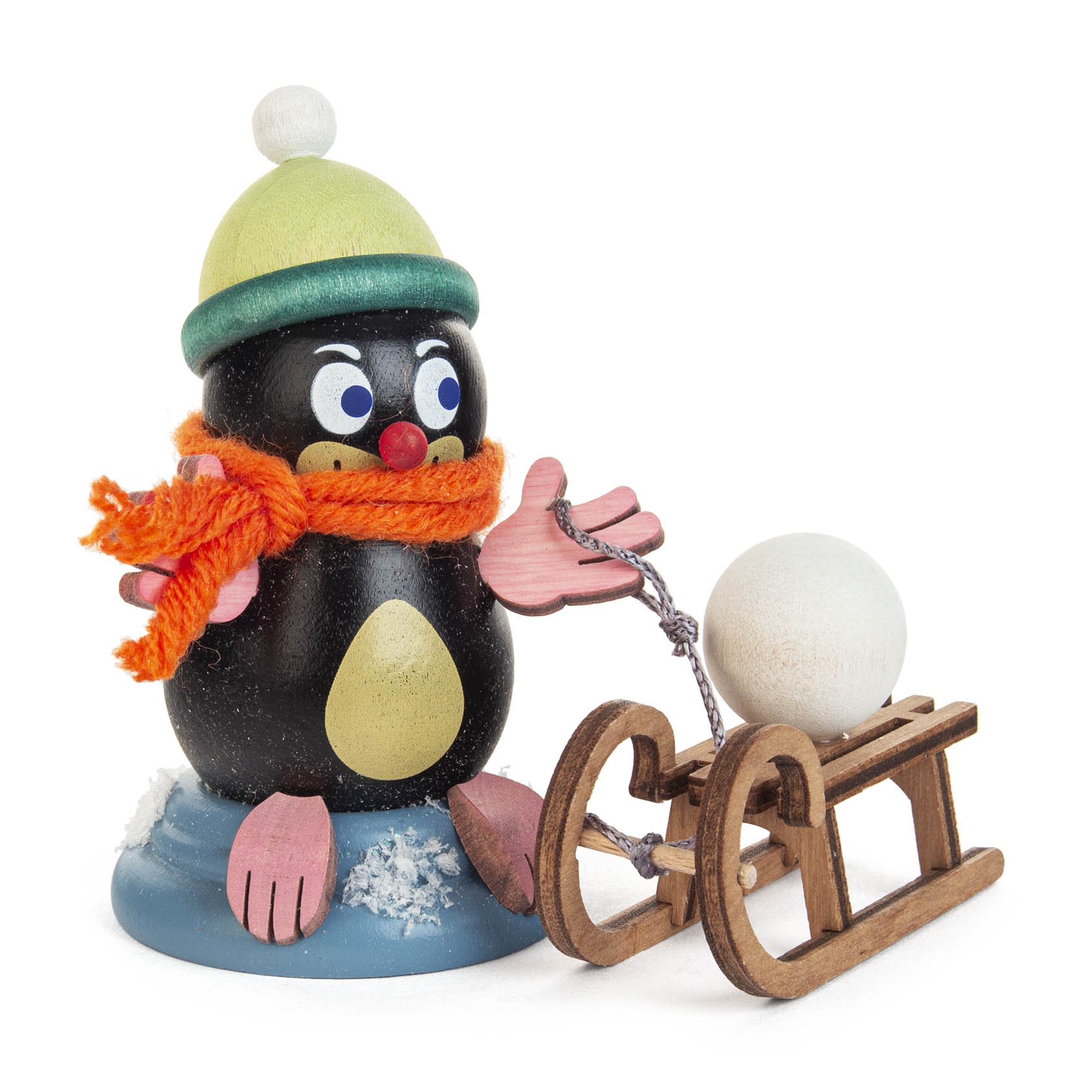 A whimsical black mole figurine named Lisa with a green hat, orange scarf, pink gloves, and red nose pulling a wooden sled with a white snowball. im Dregeno Online Shop günstig kaufen